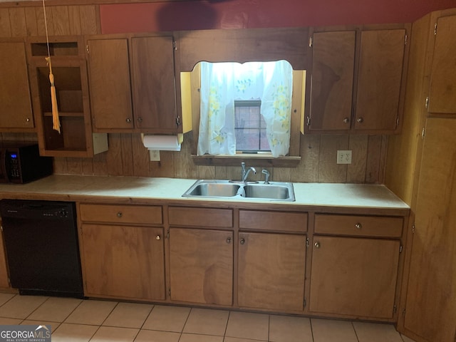kitchen featuring light tile patterned floors, stainless steel microwave, a sink, tile countertops, and black dishwasher