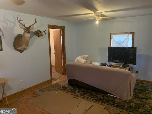 living room with baseboards and a ceiling fan