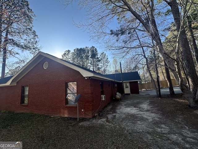 view of property exterior with fence and brick siding