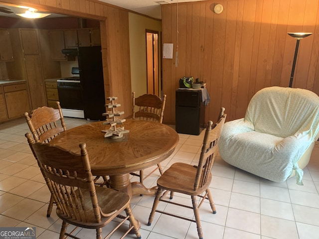 dining room with light tile patterned flooring and wood walls