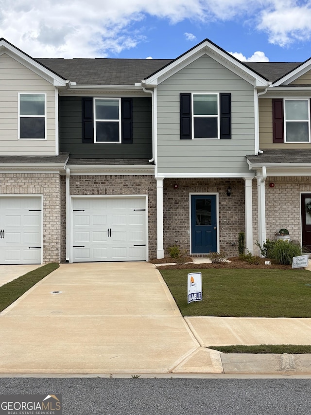 8714 Lakeview Commons Lot 48, Jonesboro, GA 30238 - townhome / multi-family property with driveway, brick siding, a garage, a shingled roof, and a front yard
