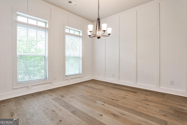 247 Franklin Rd, Atlanta, GA 30342 - unfurnished dining area with visible vents, light wood-type flooring, a decorative wall, and a chandelier