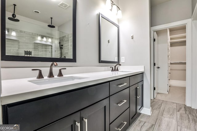 247 Franklin Rd, Atlanta, GA 30342 - bathroom featuring double vanity, visible vents, tiled shower, and a sink