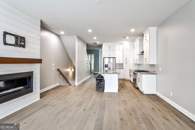 247 Franklin Rd, Atlanta, GA 30342 - kitchen featuring a kitchen bar, white cabinets, appliances with stainless steel finishes, and light wood-type flooring
