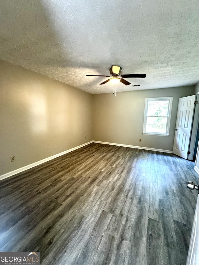 2204 Liberty Ln SW, Conyers, GA 30094 - spare room with dark wood-style flooring, a textured ceiling, and a ceiling fan