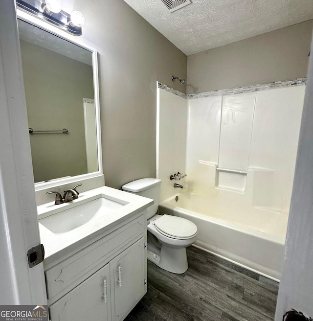 2204 Liberty Ln SW, Conyers, GA 30094 - full bath with wood finished floors, vanity, shower / bath combination, and a textured ceiling