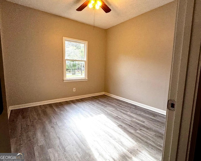2204 Liberty Ln SW, Conyers, GA 30094 - unfurnished room featuring dark wood-style floors, a ceiling fan, a textured wall, and a textured ceiling