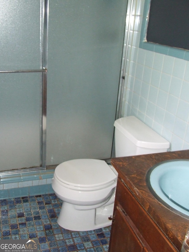 7225 Pineneedle Dr SW, Covington, GA 30014 - full bath featuring toilet, a shower stall, tile walls, vanity, and tile patterned floors
