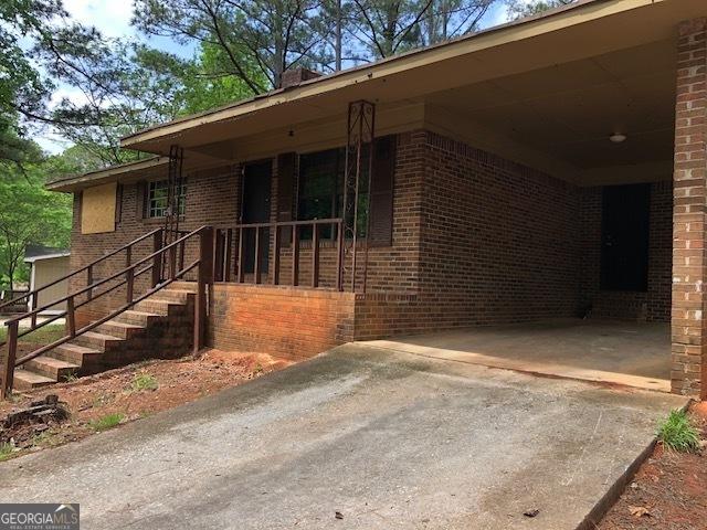 7225 Pineneedle Dr SW, Covington, GA 30014 - view of front facade with brick siding, driveway, and an attached carport