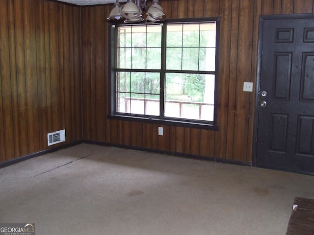 7225 Pineneedle Dr SW, Covington, GA 30014 - unfurnished dining area featuring wood walls, carpet, and a chandelier