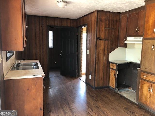 7225 Pineneedle Dr SW, Covington, GA 30014 - kitchen with a sink, dark wood-style flooring, light countertops, and under cabinet range hood