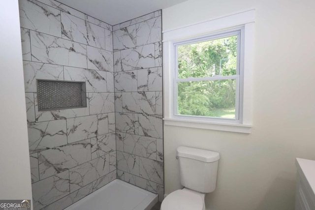 bathroom featuring toilet and a tile shower