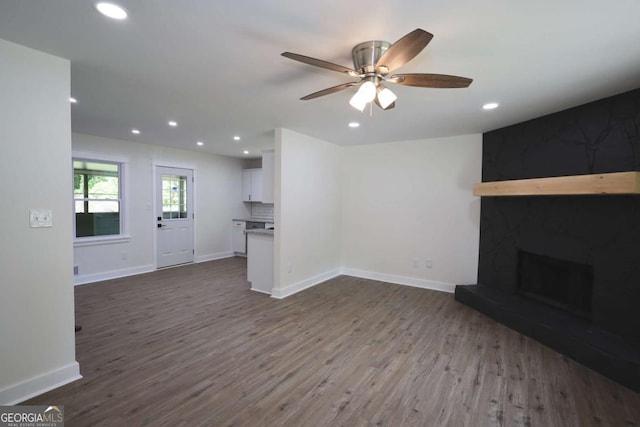 unfurnished living room with dark wood-type flooring, recessed lighting, and baseboards