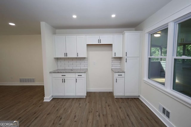 kitchen featuring white cabinets, backsplash, dark wood-type flooring, and visible vents