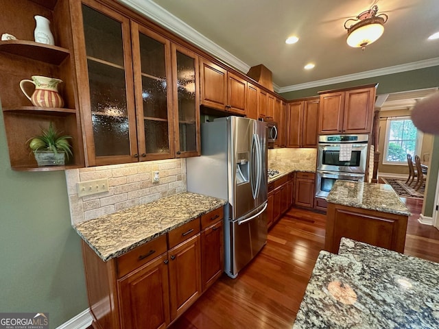 3397 Holly Glen Dr, Dacula, GA 30019 - kitchen featuring crown molding, appliances with stainless steel finishes, light stone counters, and dark wood-style floors