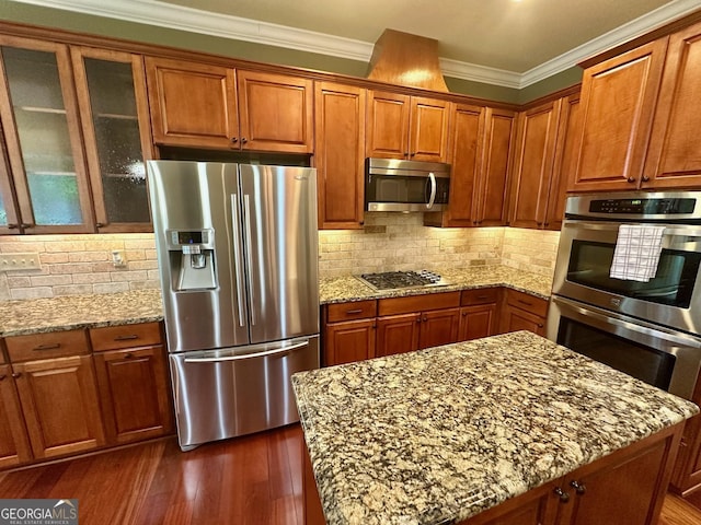 3397 Holly Glen Dr, Dacula, GA 30019 - kitchen with brown cabinetry, ornamental molding, appliances with stainless steel finishes, and light stone counters
