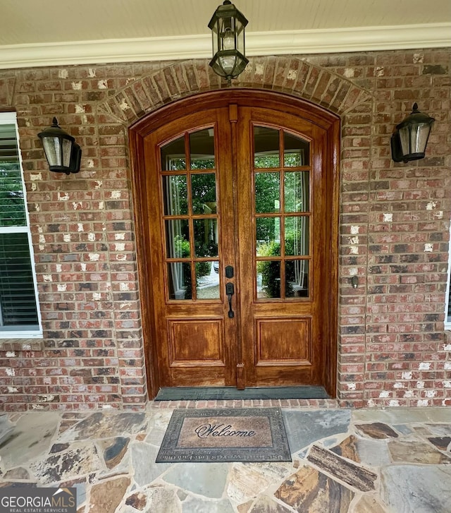 3397 Holly Glen Dr, Dacula, GA 30019 - view of exterior entry featuring french doors, a porch, and brick siding