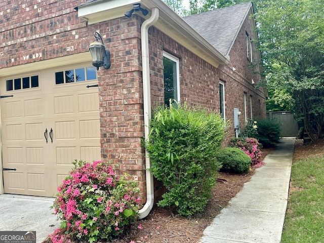3397 Holly Glen Dr, Dacula, GA 30019 - view of home's exterior with brick siding, a garage, and roof with shingles