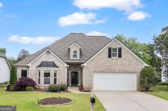 view of front of house with brick siding, a front lawn, an attached garage, and driveway