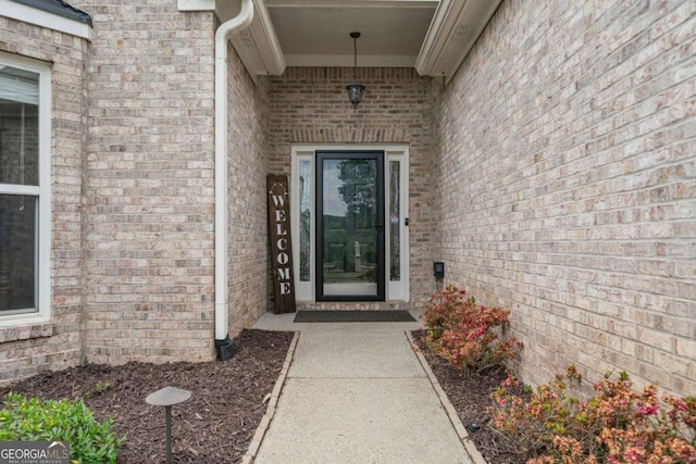doorway to property featuring brick siding