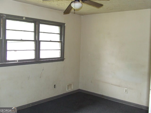 spare room featuring a ceiling fan and baseboards