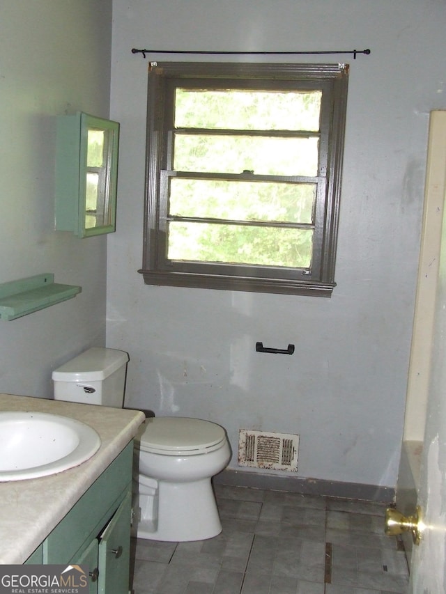 bathroom featuring vanity, toilet, and tile patterned floors
