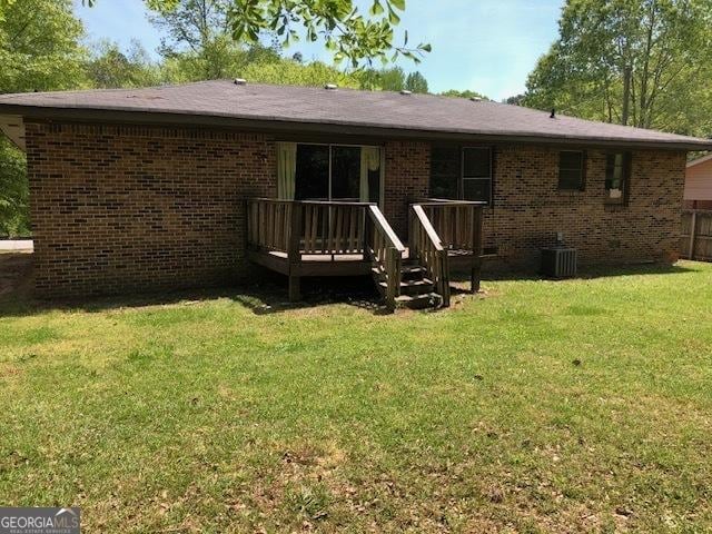 rear view of property featuring a deck, brick siding, and cooling unit
