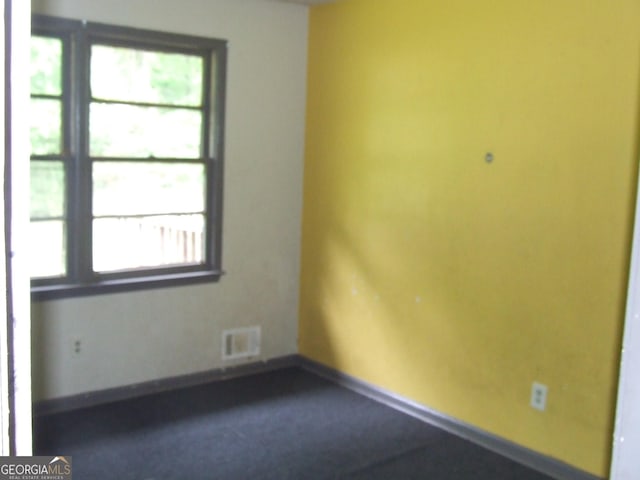 empty room featuring baseboards and carpet flooring