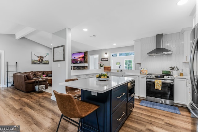 620 Clearbrook Ct, Marietta, GA 30068 - kitchen with wall chimney exhaust hood, stainless steel appliances, light countertops, light wood-type flooring, and white cabinetry