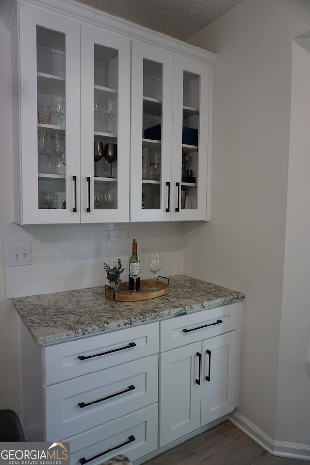 2566 Summit Cove Dr, Duluth, GA 30097 - bar area featuring decorative backsplash, baseboards, and wood finished floors