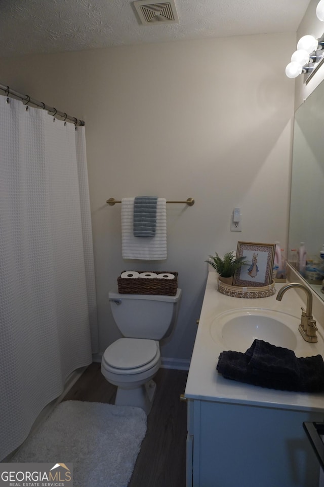 2566 Summit Cove Dr, Duluth, GA 30097 - full bathroom with vanity, wood finished floors, toilet, a textured ceiling, and a shower with shower curtain