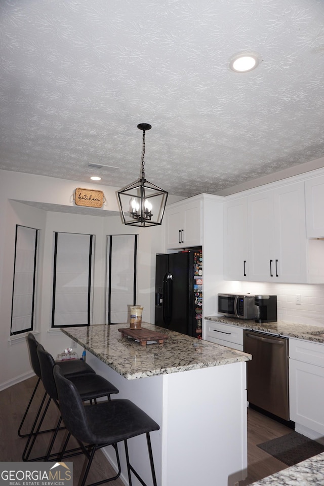 2566 Summit Cove Dr, Duluth, GA 30097 - kitchen featuring stainless steel appliances, dark wood-style flooring, a chandelier, white cabinetry, and a kitchen bar