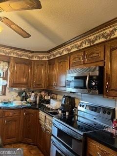 kitchen featuring dark countertops, stainless steel appliances, and ceiling fan