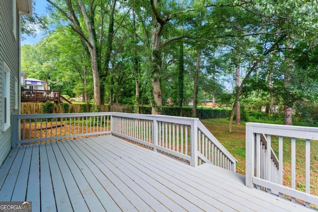 wooden deck with a yard and a fenced backyard