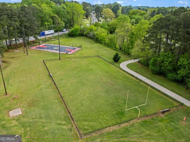view of community featuring a lawn, fence, and a pool