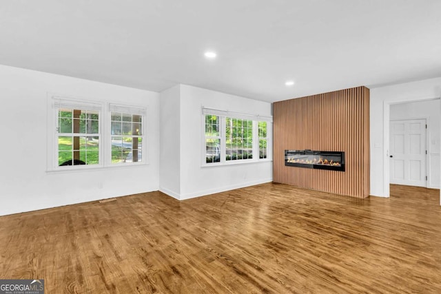 276 Greentree Pkwy, Macon, GA 31220 - unfurnished living room featuring a glass covered fireplace, baseboards, recessed lighting, and wood finished floors