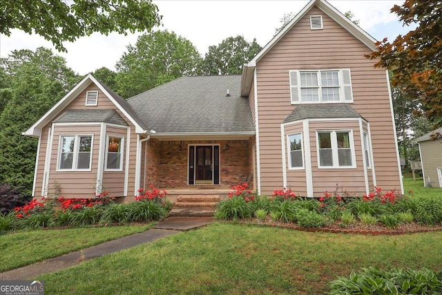 traditional home with a shingled roof, covered porch, and a front yard