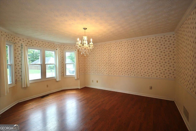 empty room featuring dark wood-style flooring, an inviting chandelier, wallpapered walls, visible vents, and ornamental molding