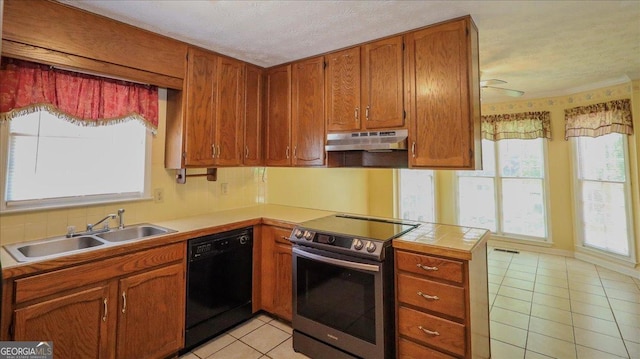 kitchen featuring stainless steel electric range oven, light tile patterned flooring, a sink, black dishwasher, and under cabinet range hood
