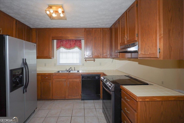 kitchen featuring light tile patterned floors, appliances with stainless steel finishes, under cabinet range hood, and brown cabinets