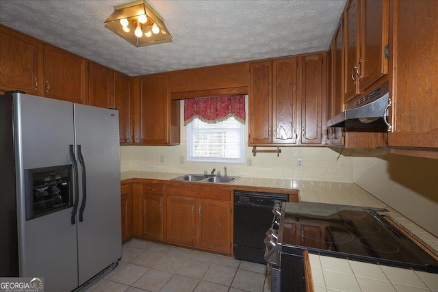 kitchen with electric range, black dishwasher, stainless steel fridge, tile countertops, and under cabinet range hood