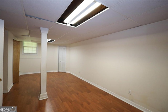 basement featuring wood finished floors, baseboards, and a drop ceiling