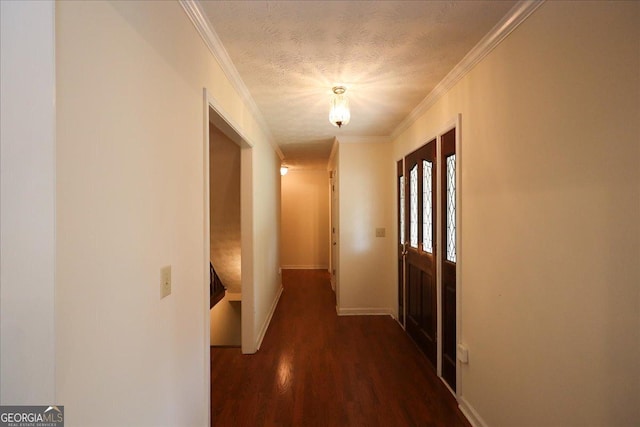 hallway with a textured ceiling, baseboards, ornamental molding, and wood finished floors