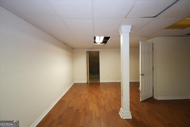 finished basement featuring baseboards, wood finished floors, and a paneled ceiling