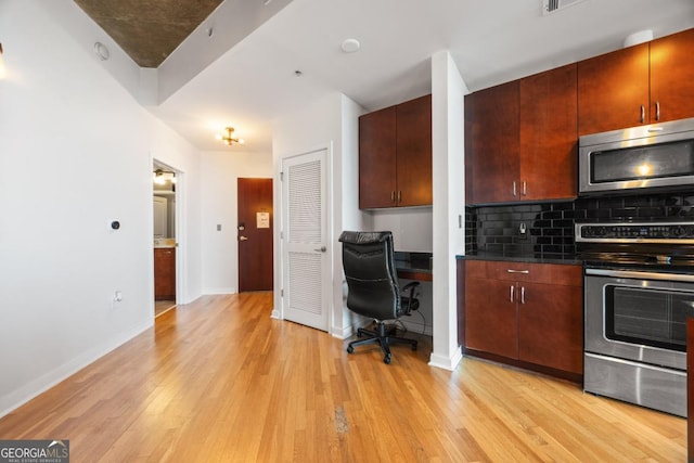 400 W Peachtree St NW Unit 3614, Atlanta, GA 30308 - kitchen with light wood-style flooring, appliances with stainless steel finishes, dark countertops, backsplash, and baseboards