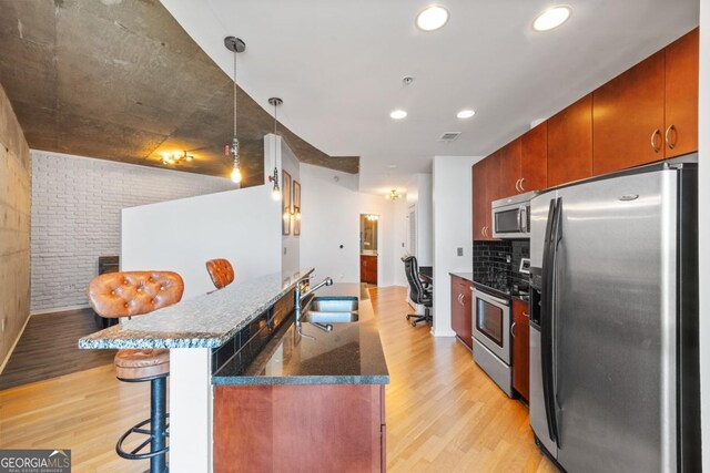 400 W Peachtree St NW Unit 3614, Atlanta, GA 30308 - kitchen with a sink, appliances with stainless steel finishes, a kitchen bar, light wood-type flooring, and backsplash