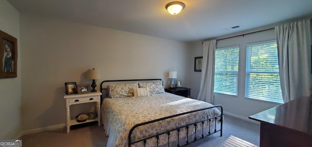 carpeted bedroom featuring baseboards and visible vents