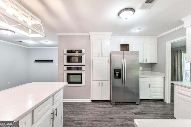 kitchen with crown molding, dark wood finished floors, and stainless steel appliances