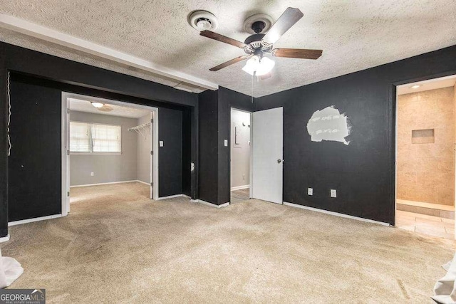 interior space with baseboards, a textured ceiling, and ceiling fan