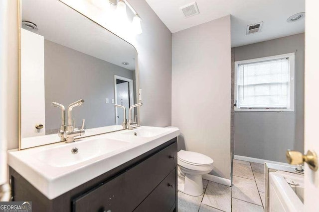 bathroom with a sink, toilet, double vanity, and visible vents